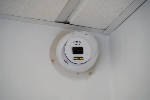 Close up of security surveillance camera mounted on interior wall Stock Photos