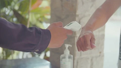 Close-Up of Security's Hand Checking Temperature of Man's Hand Stock Footage 162297637