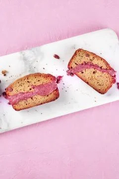 A close-up of a seed cake with ruby chocolate, shot from the top on a pink Stock Photos