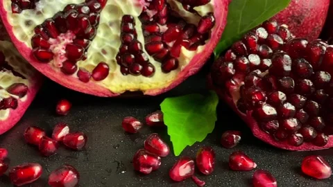 Close-up segments with fresh pomegranate arils on black background Stock Footage 233015323