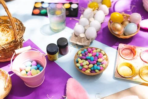 Close up of selection of colorful easter eggs and paints on table Foto stock