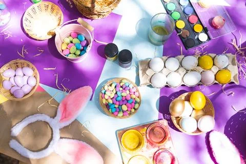 Close up of selection of colorful easter eggs and paints on table 스톡 사진
