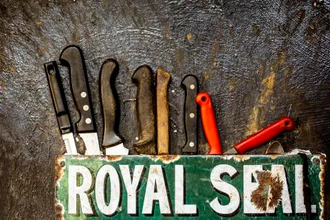 Close up of a selection of sharp knives and tools on a wall. Stock Photos