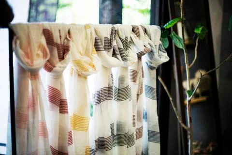 Close up of selection of white hand dyed scarves with stripes and natural plant Stock Photos
