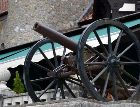 Close up selective focus image of an old medieval wooden wheeled cannon locat Stock Photos
