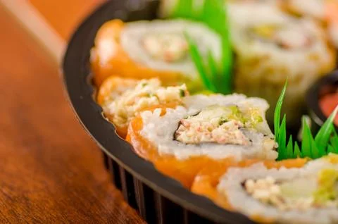 Close up of selective focus of large set of japanese rolls on a black plastic 스톡 사진