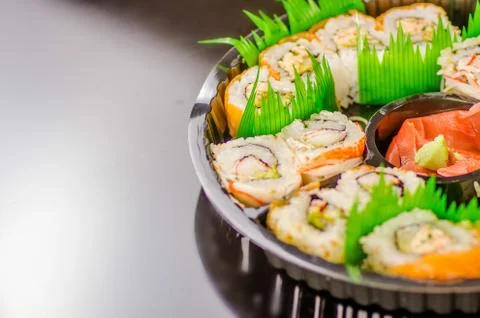 Close up of selective focus of large set of japanese rolls on a black plastic Stock-Fotos