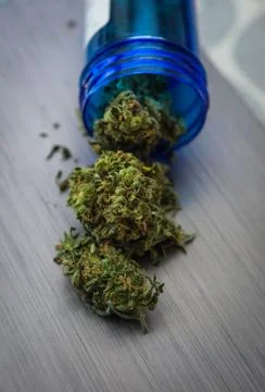 Close up selective focus on marijuana spilled out of medicine container Stock Photos