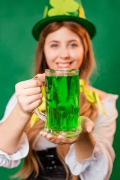 Close up, selective focus of a mug with green beer in the hands of a waitress Stock Photos