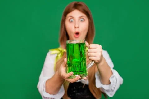 Close up, selective focus of a mug with green beer in the hands of a waitress Stock Photos