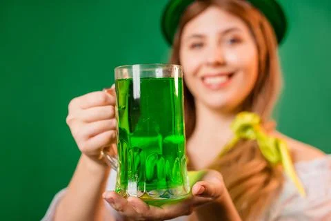 Close up, selective focus of a mug with green beer in the hands of a waitress Stock Photos