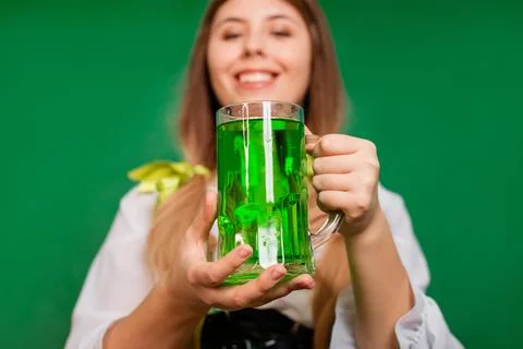 Close up, selective focus of a mug with green beer in the hands of a waitress Stock Photos