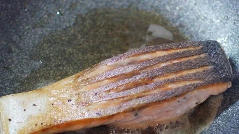 Close up with selective focus to a pan while fried sear grill salmon filet .. Stock Footage 276353382