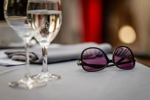 Close-up selective focus photography. On the table are sunglasses and wine gl Foto stock