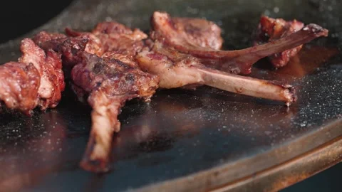 A close-up, selective focus shot of juicy lamb chops cooking on a hot barbecue 動画素材 345499466