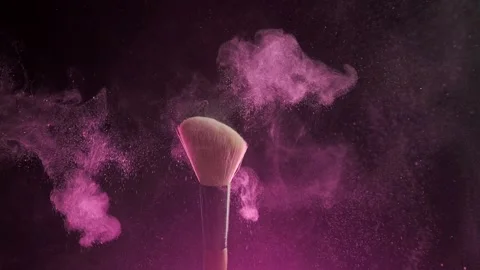 Close up selective focus shot of shimmer powder being shaken off makeup brush Video stock 194395512