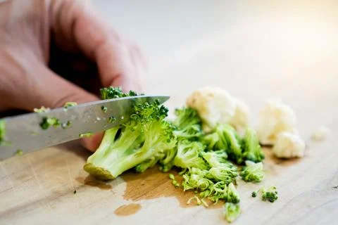 Close up selective focus view of Broccoli and cauliflower being cut with a knife Stock Photos