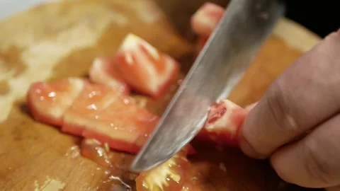 Close up with selective focusing of hand while cutting fresh red tomato wit.. Video stock 293928291