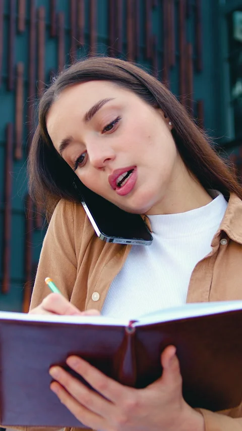 Close up of self employed female making phone call on mobile phone and taking no Stock Footage 327547904