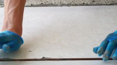 Close-up self-laying ceramic tiles at home on the floor by non-professionals. Stock Footage 112625539