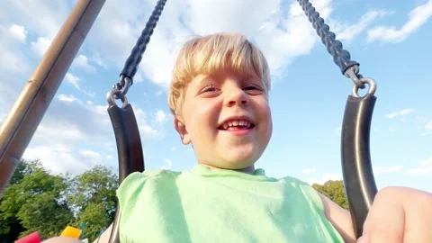 Close selfie view of a little boy sit on swings at playground Video stock 204876227
