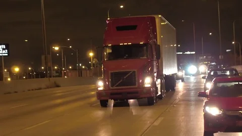 CLOSE UP: Semi truck hauling freight container on multiple lane highway at night Stock Footage