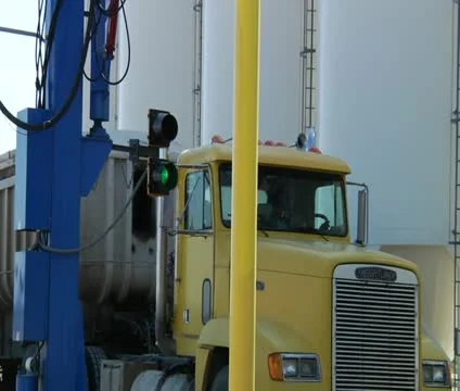 Close-up on semi truck pulling through industrial machinery Stock Footage 21592492
