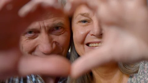 Close up of senior beautiful couple doing heart shape with hands at home Stock Footage 141205117