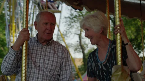 Close up of senior couple riding carousel at carnival / American Fork, Utah, Vídeo Stock 33848072