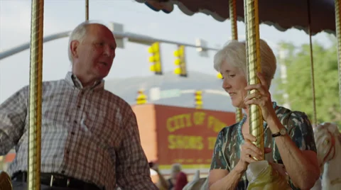 Close up of senior couple riding carousel at carnival / American Fork, Utah, Vídeo Stock 33848077