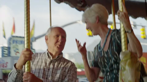 Close up of senior couple riding carousel at carnival / American Fork, Utah, Vídeo Stock 33848082