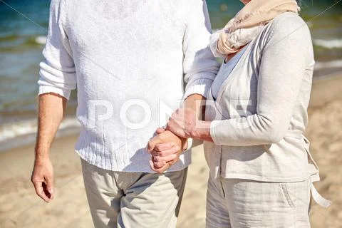 Close up of senior couple walking on summer beach Stock Photos