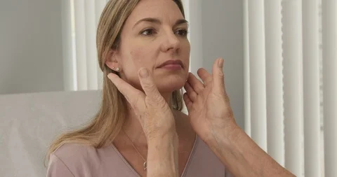 Close up of senior doctor feeling lymph nodes on female Caucasian patient Stock Footage 102770837