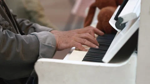 Close up of Senior elderly man hands while playing the piano outside Stock Footage 212389239