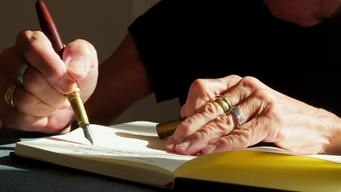 Close-up of senior hands writing in a notebook using a fountain pen Stock Footage 333485203