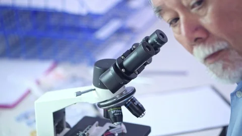 Close up on senior lab scientist looking into microscope. Stock Footage 92394919
