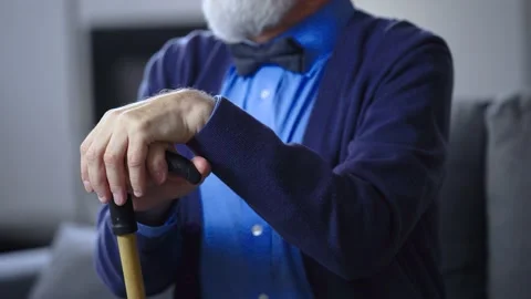 Close-up of senior man holding a cane, rubbing hands, waiting for someone Stock Footage 236007931
