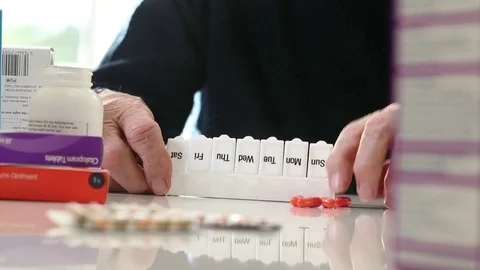 Close Up Of Senior Man Organizing Medication Into Pill Dispenser Stock Footage