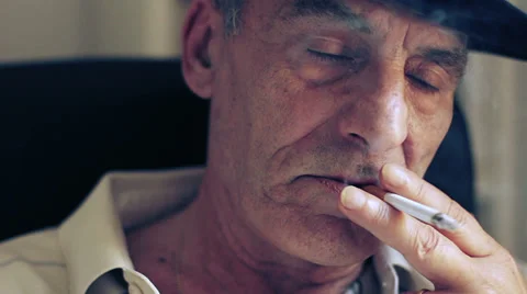 Close-up of a senior man thinking about something and smokes a cigarette Stock Footage 32357994