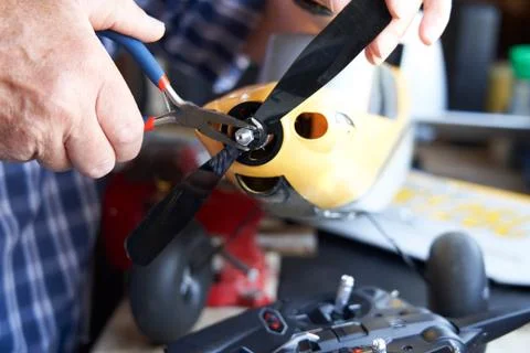 Close Up Of Senior Man Working On Model Radio Controlled Aeroplane In Shed At Stock Photos