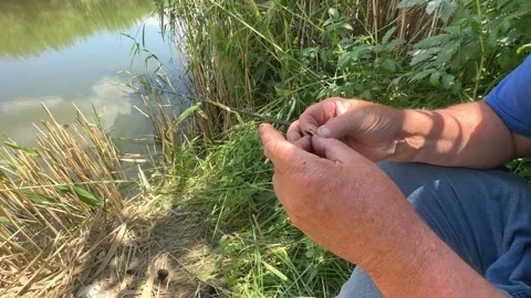 Close up senior Men's hands put bait on hook to fish with fishing rod. Lifestyle Stock Footage 245107027