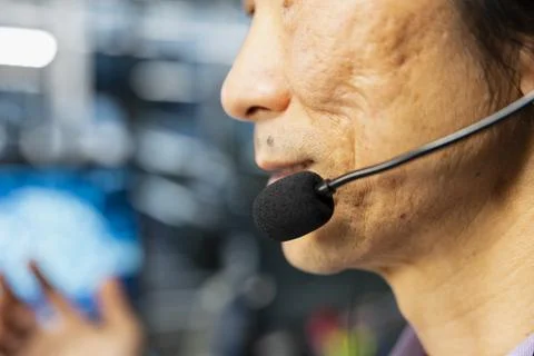 Close up of senior programmer in data center speaking in headset mic Stock Photos