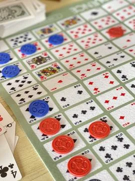 Close-Up of Sequence Board Game in Progress with Cards and Chips Foto stock