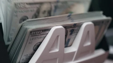Close-up sequence of cash counting machine processing stacks of hundred-dollar Stock Footage 333978874