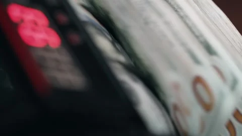 Close-up sequence of cash counting machine processing stacks of hundred-dollar Stock Footage 333979090
