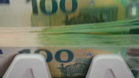Close-up sequence of euro banknotes being processed through a currency counting Stock Footage 333978996