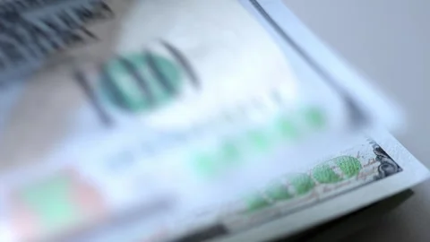 Close-up sequence of hundred-dollar bills being stacked, showcasing intricate Stock Footage 325141115