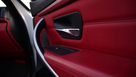 Close-up sequence of a luxurious car door interior showcasing rich red leather Stock Footage 329565465