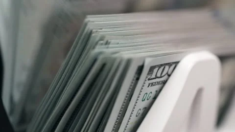 Close-up sequence of stacks of hundred-dollar bills being organized in a white Stock Footage 333979043