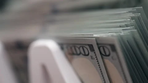 Close-up sequence of US dollar bills stacked in a white money holder, showcasing Stock Footage 333979264